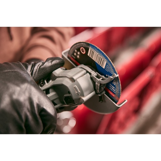 STANLEY STA32637 photography of gloved hand holding angle grinder with abrasive disc in close-up view.