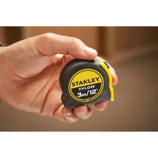 Photo of STANLEY 0-30-686 tape measure, black and yellow, 3m/12ft, held in a hand.