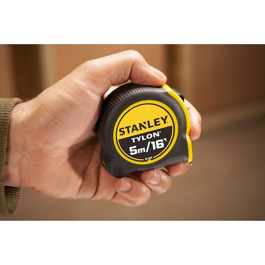 Photo of STANLEY 0-30-696 Tylon 5m/16ft tape measure held in hand, black and yellow casing.