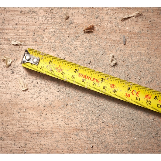 STANLEY 0-30-696 yellow tape measure on dusty wooden surface, product photography