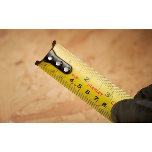 Close-up photo of STANLEY 0-33-805 tape measure with yellow blade and clear metric and imperial markings.