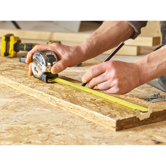 Stanley 0-33-892 tape measure for woodworking, shown measuring on plywood surface.