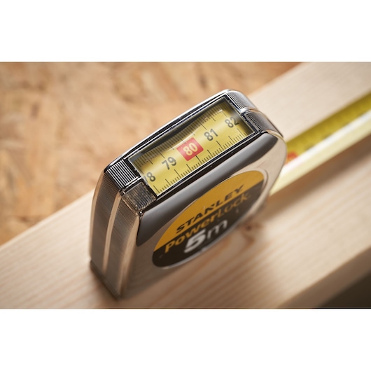 STANLEY 0-33-932 measuring tape close-up, yellow blade showing 80 cm mark, photography on wood surface.