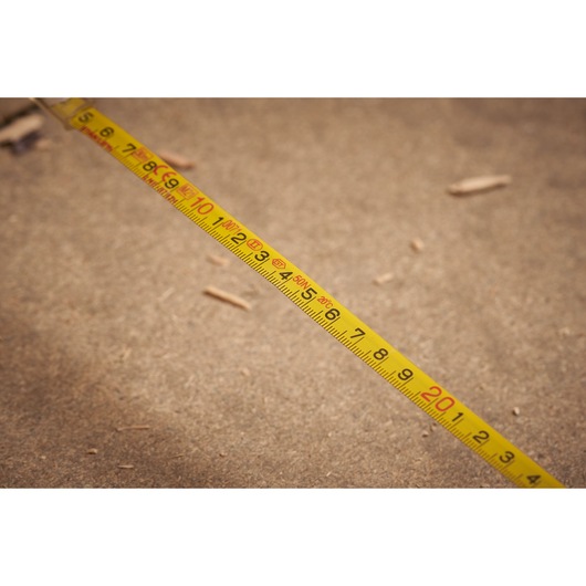 STANLEY 0-34-203 yellow measuring tape on a wood surface, photography close-up.