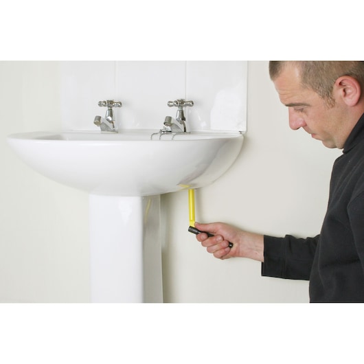 STANLEY 0-70-453 angle screwdriver in use under a white bathroom sink, side view.