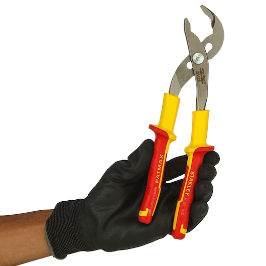 A gloved hand holds Stanley insulated pliers with yellow and red handles, suitable for electrical work.