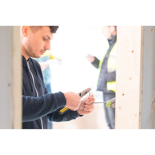STANLEY 0-89-868 pliers in use by worker stripping wire in construction setting.