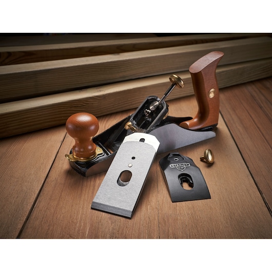 Photo of STANLEY 1-12-136 hand plane with wood handles and disassembled blades on wood surface.