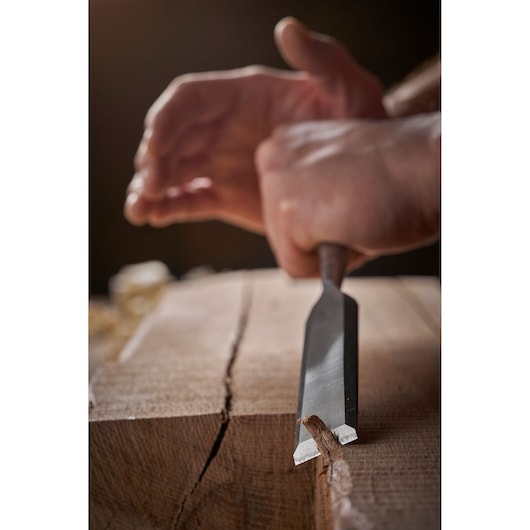 STANLEY 1-16-793 chisel tool in use carving wood, close-up side angle photography.