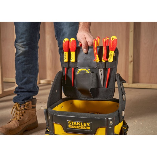 STANLEY 1-93-952 tool bag with yellow handles, open front angle, on construction site floor.