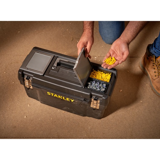 STANLEY 1-94-858 tool box with open lid, showing yellow wall plugs and metal fasteners, top angle.