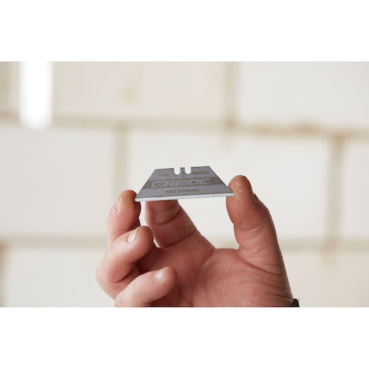 Photo of STANLEY 2-11-800 carbide utility blade held in a hand, product close-up, photography category.