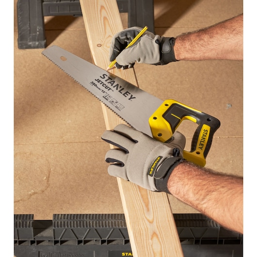 STANLEY 2-15-281 hand saw held on wooden plank, worker marking cut line, product photography.