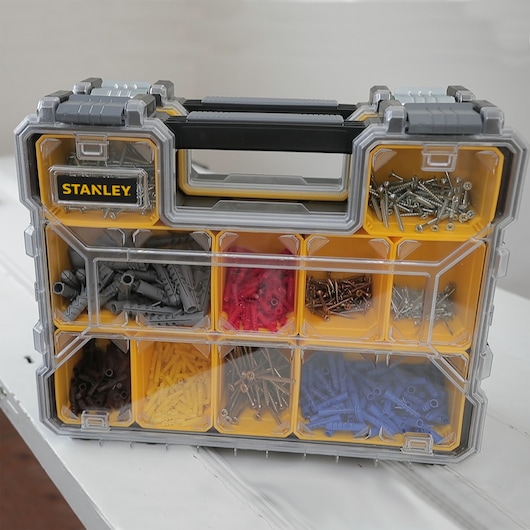 STANLEY 22910 organizer box with assorted screws and wall plugs, front angle, yellow and clear compartments.