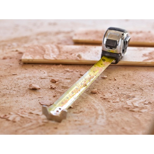 STANLEY 5-33-891 tape measure extended on dusty wood surface, close-up angle.