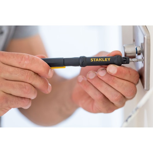 Photo of STANLEY 66-344M screwdriver in use tightening a screw on a lock, close-up view.