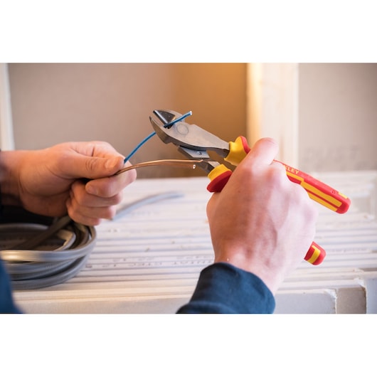 Photo of STANLEY 84-004-S insulated diagonal cutting pliers cutting blue electrical wire.
