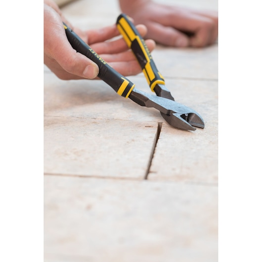 STANLEY 89-861 diagonal cutting pliers with black and yellow handles in use on tile surface, close-up.