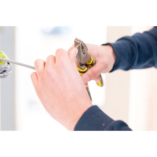 Photo of STANLEY 89-868 pliers cutting wire, close-up of tool in use for electrical work.