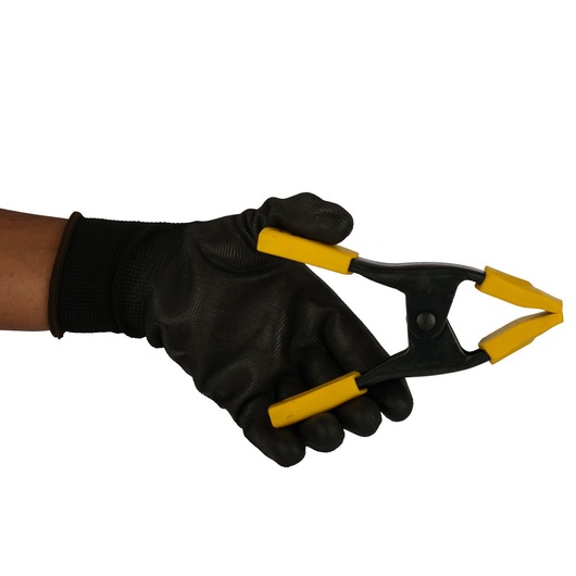STANLEY 9-83-080 photography of black and yellow spring clamp held in gloved hand, side angle.