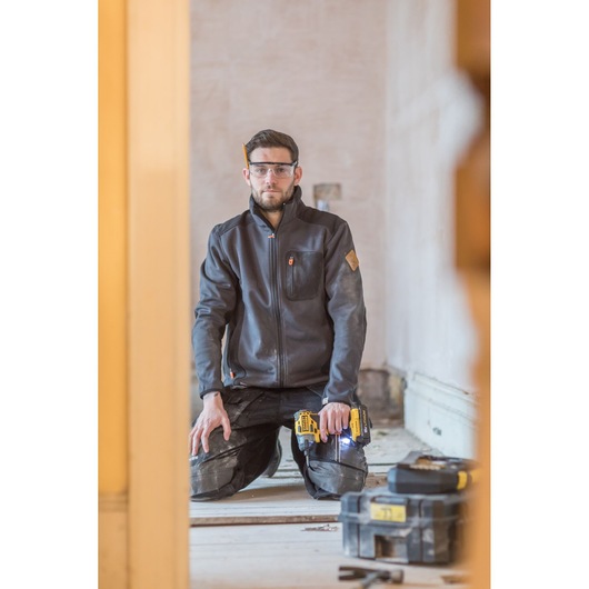 STANLEY FMC647D2 cordless drill in use on job site, worker kneeling with drill, toolboxes on floor.