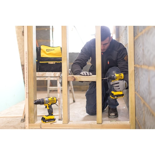 Stanley FMCK461C2 cordless drill set used for wood framing, with Stanley tool bag in background.