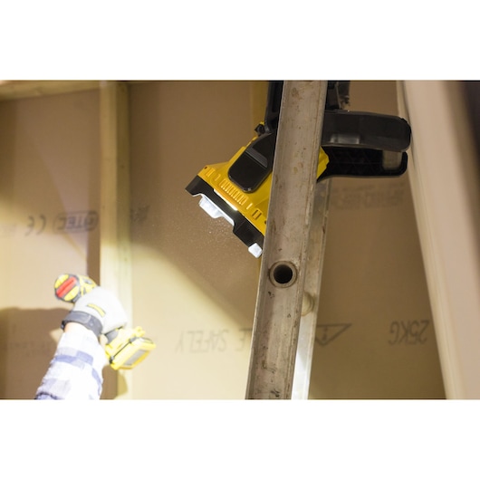 STANLEY FMCL001B LED work light clamped to a ladder, illuminating a construction area.