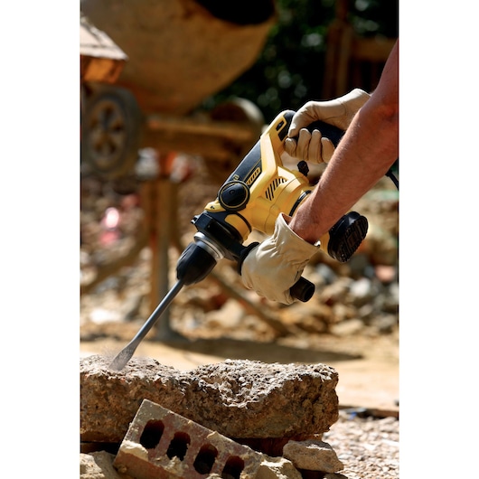 STANLEY FME1250K rotary hammer drill in use on concrete at construction site, close-up photography.