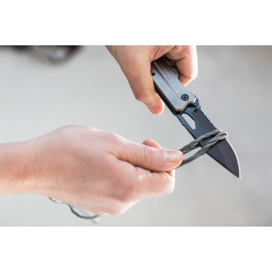 STANLEY FMHT0-10312 folding knife cutting wire, close-up view of hands using the knife.
