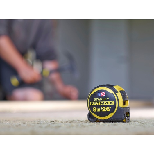 STANLEY FMHT0-36326 tape measure FATMAX 8m/26' with yellow and black casing, close-up photography on worksite.