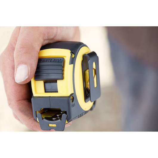 Photo of STANLEY FMHT0-36337 tape measure, yellow and black, close-up in hand.