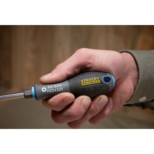 Photo of STANLEY FATMAX FMHT0-62624 screwdriver with black and yellow handle held in a hand, showing close-up detail.