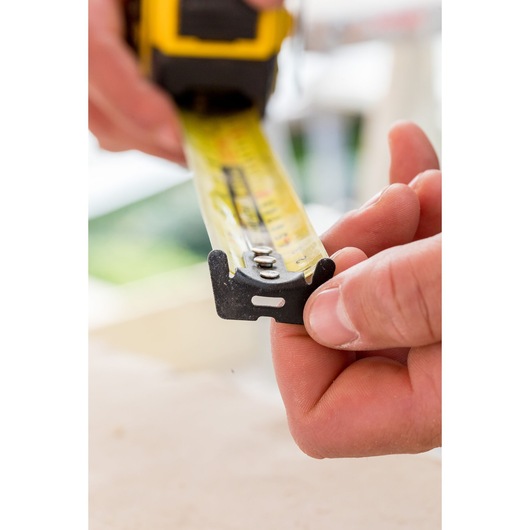 STANLEY FMHT36317-0 tape measure close-up, yellow blade held by hand, product in use.