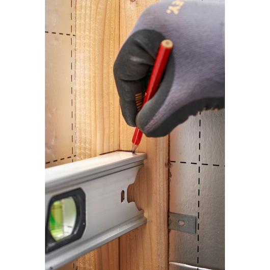 STANLEY FMHT43676-1 photography of hand marking wood with pencil beside aluminum level.