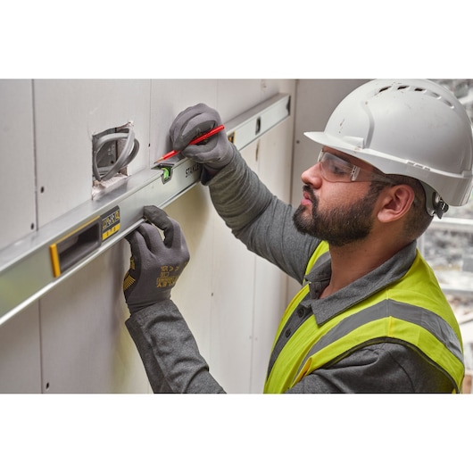 Photo of STANLEY FMHT43679-1 spirit level used for marking on drywall during construction.