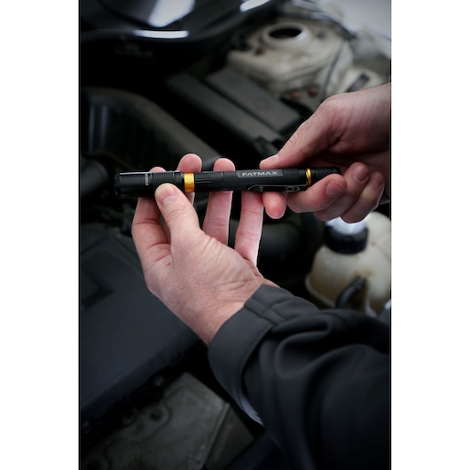 Stanley FMHT81510-0 FATMAX black pen light held by hands near car engine, product in use.