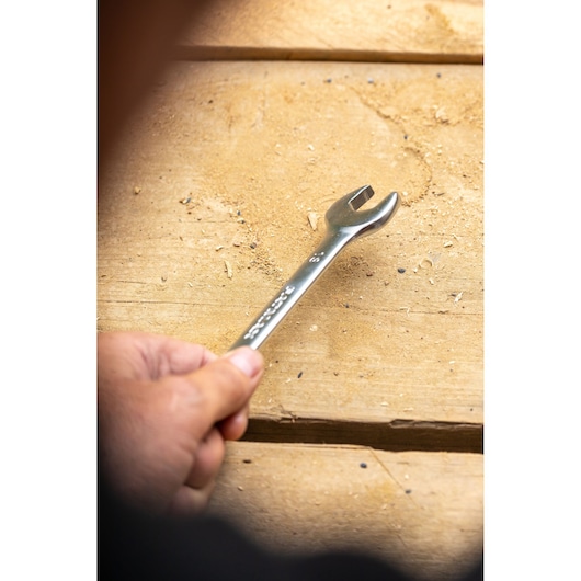 STANLEY FMMT82849-0 wrench held by hand on wooden surface, tool photography.