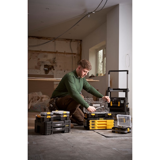 STANLEY FMMT98102-0 stackable organizer toolboxes with clear lids shown in a workspace with a worker.