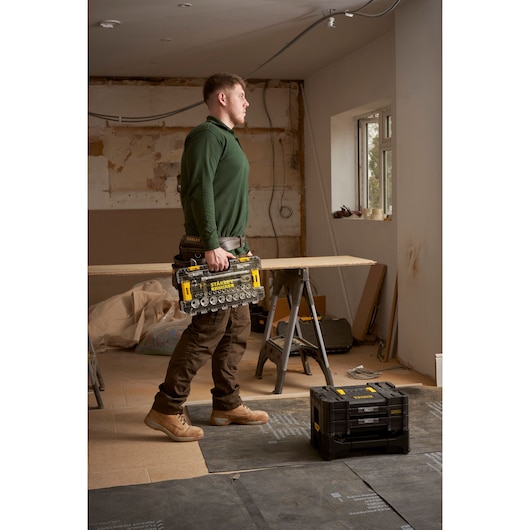 STANLEY FMMT98103-1 tool organizer with clear compartments held by person in work clothes on jobsite.