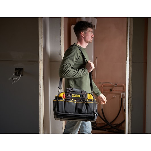 Stanley FMST1-73607 tool bag with shoulder strap and tools, photography in a construction setting.