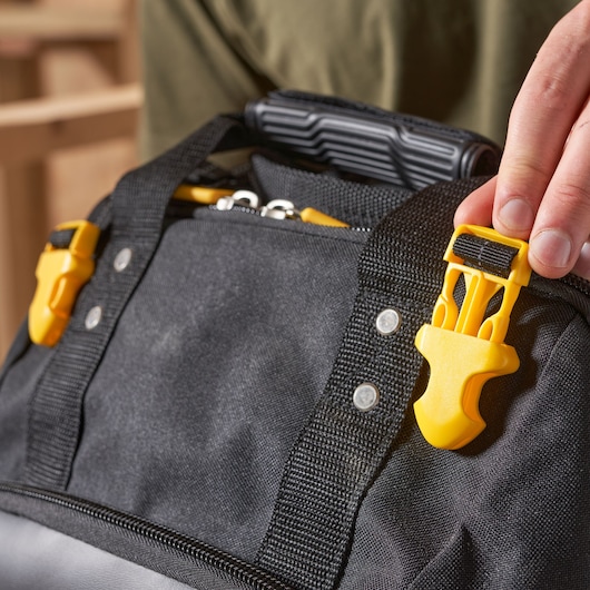 STANLEY FMST1-80144 tool bag close-up showing yellow plastic buckles and black fabric handle.