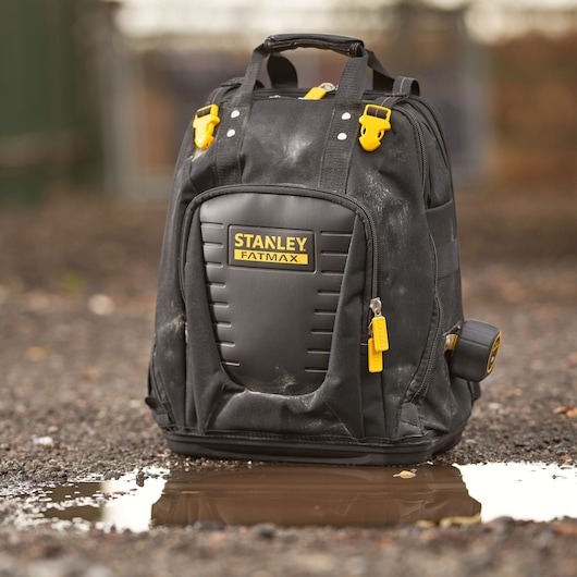 STANLEY FMST1-80144 backpack with yellow clips and side tape measure, outdoor front view.