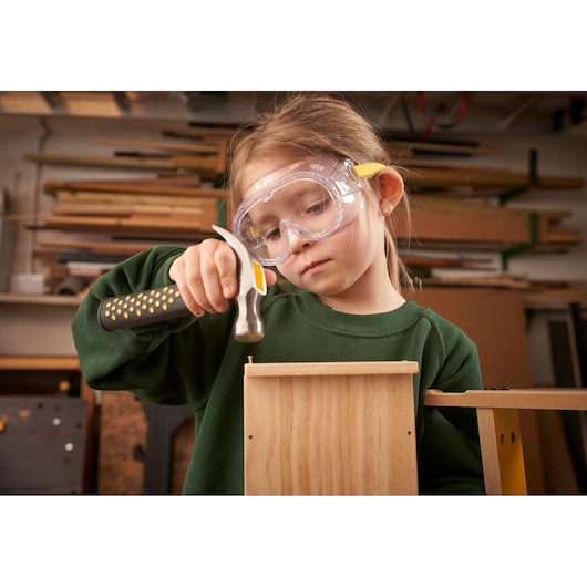 STANLEY K020-SY hammer with yellow handle used in woodworking, indoor workshop setting.