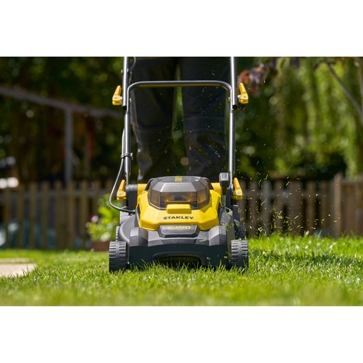 STANLEY SCMWP3701M2 cordless lawn mower front view cutting grass outdoors.