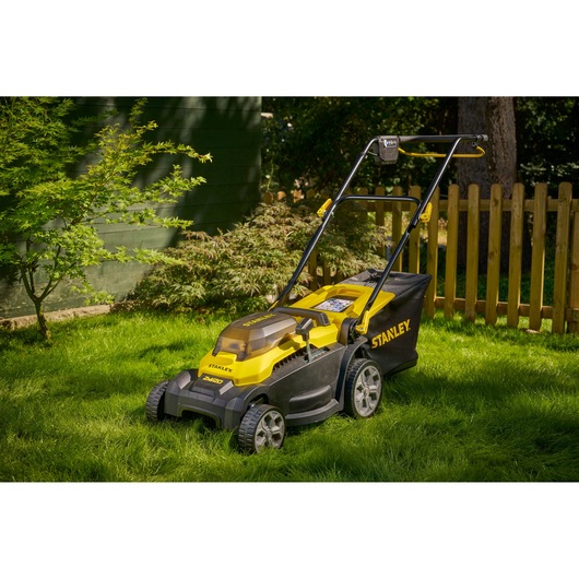 STANLEY SCMWP3701M2 lawn mower in yellow and black on grass, side angle, outdoor garden setting.