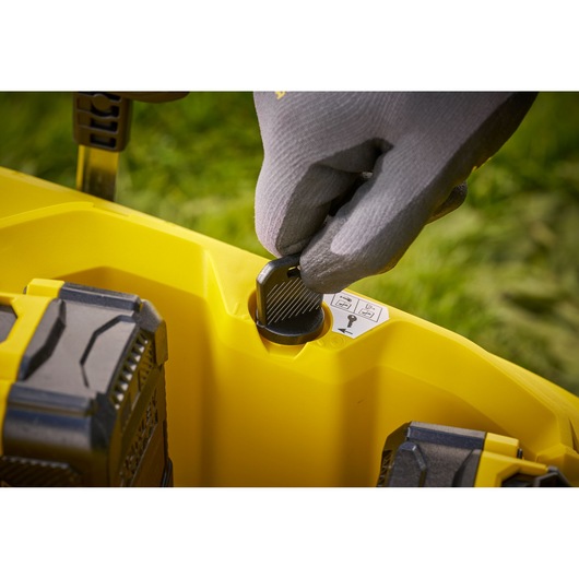 STANLEY SCMWP3701M2 lawn mower close-up, gloved hand turning ignition key in yellow housing.