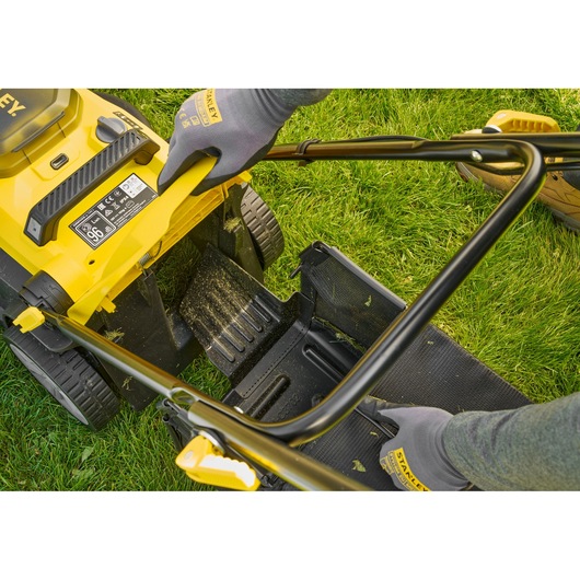 STANLEY SCMWP3701N lawn mower rear view, showing grass catcher installation on green lawn.