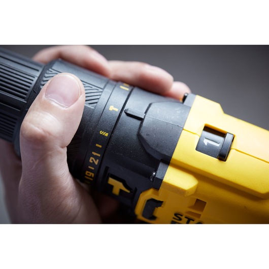 STANLEY SFMCD711D21 yellow cordless drill close-up, showing grip and settings controls.