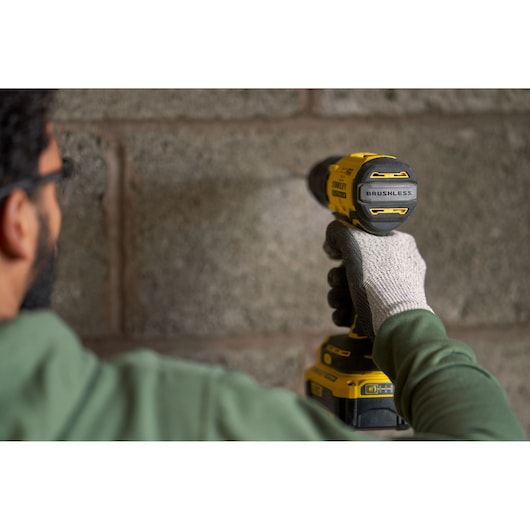 Photo of STANLEY SFMCD715M12 cordless brushless drill in use, rear angle, yellow and black body.