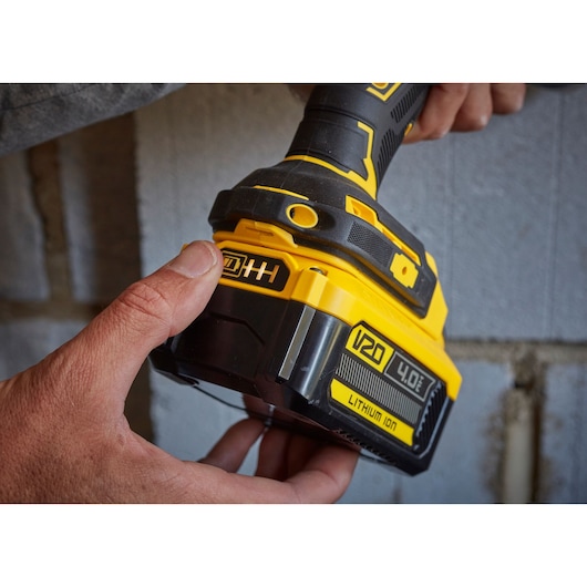 Photo of STANLEY SFMCD715M12 cordless drill being held, close-up on yellow and black V20 4.0Ah lithium-ion battery.